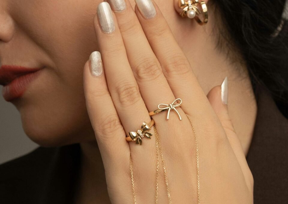Woman wearing fine gold jewelry with pearl accents, editorial soft light