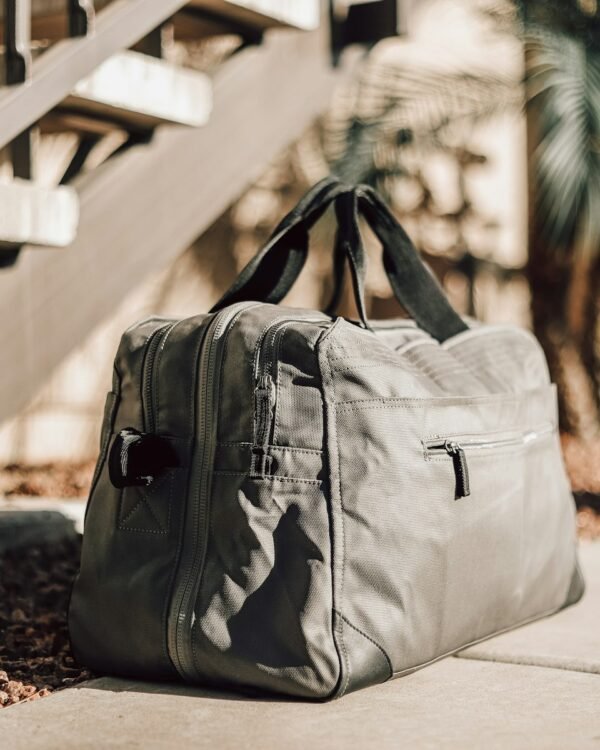 Gray leather duffel bag on neutral background